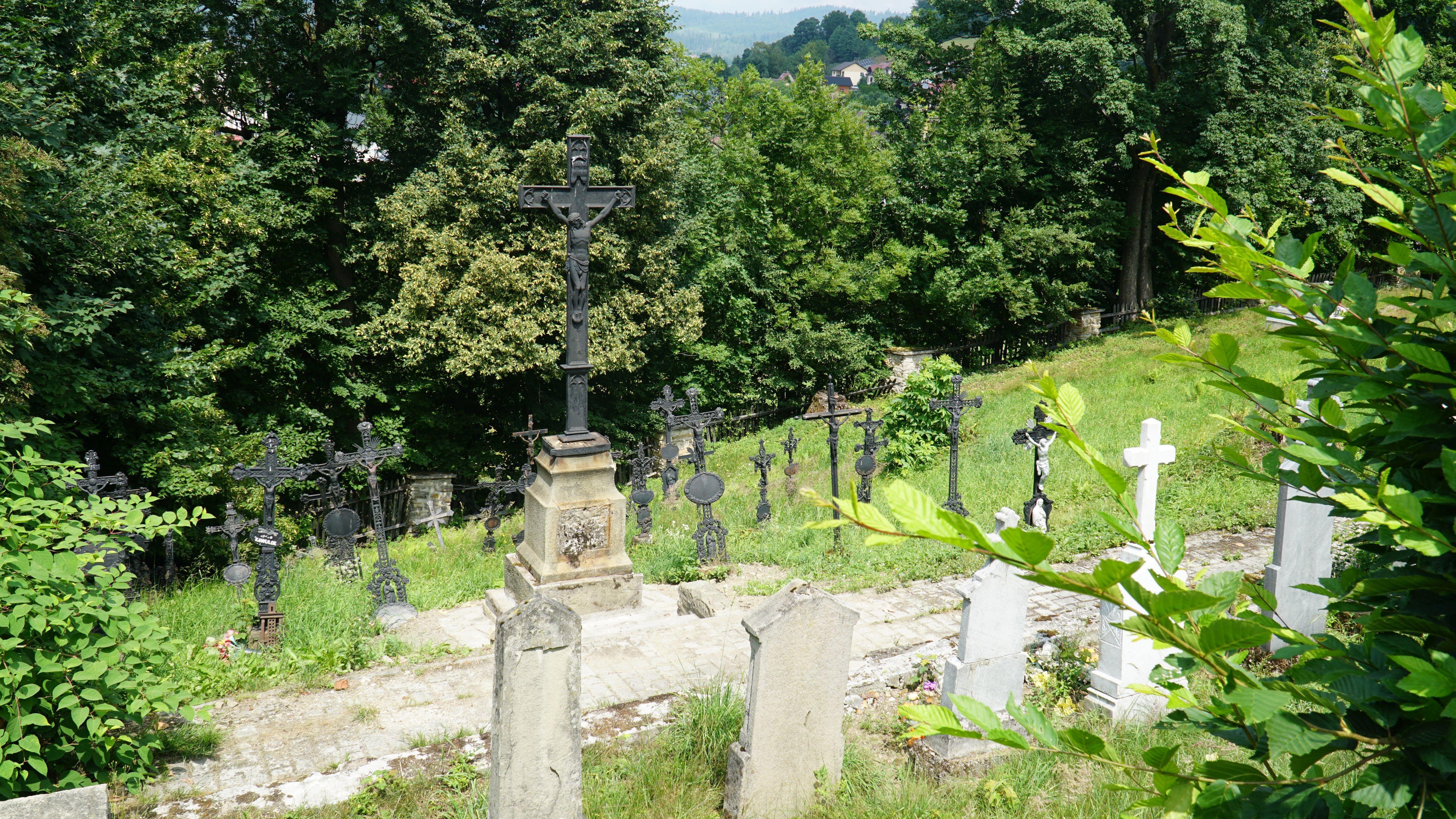Fragment starego cmentarza usytuowanego na zboczu wzniesienia. Na pierwszym planie widocznych
jest kilka kamiennych mogił, w tle zaś widać kilkanaście żeliwnych krzyży.