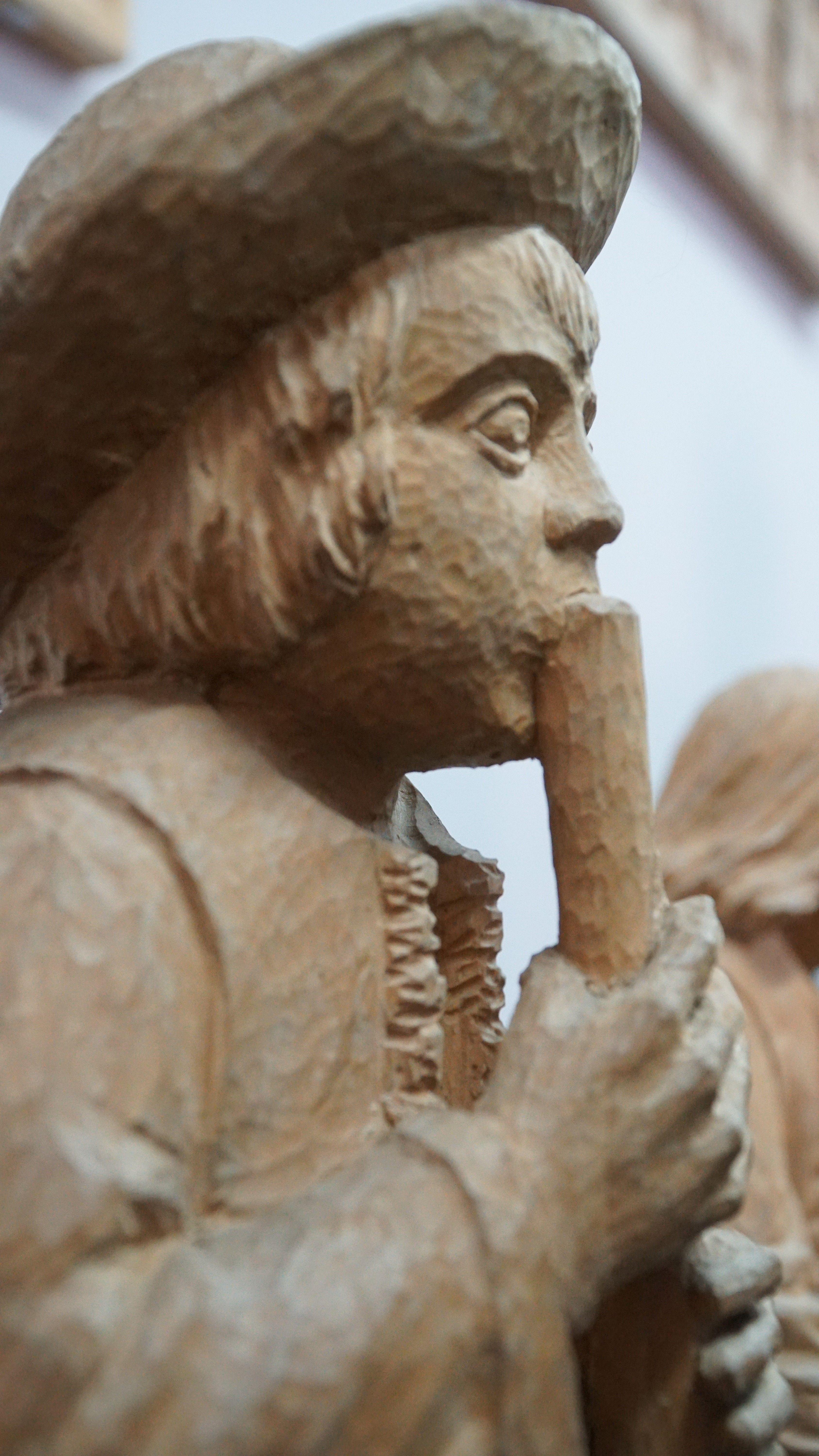 Drewniana rzeźba młodego górala grającego na fujarce.
